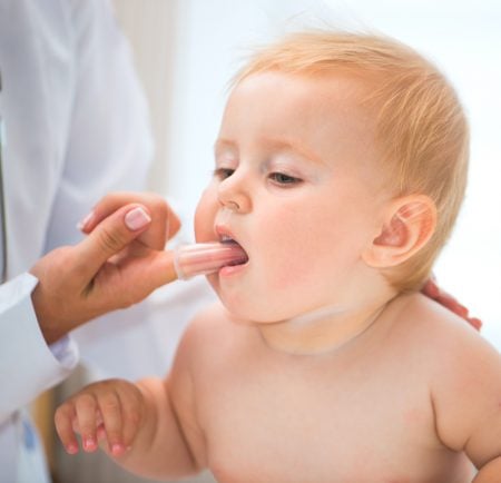 checking a young child for new teeth