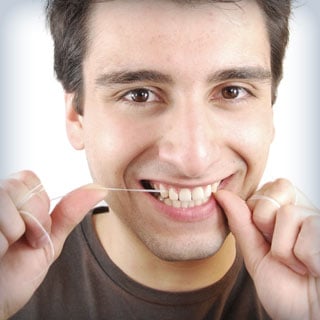 man flossing teeth